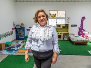 Una mujer sonriente de pie en un cuarto de juegos infantil