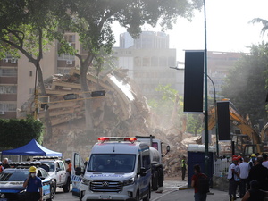 Equipos de búsqueda y rescate trabajan entre los escombros de un edificio derrumbado.