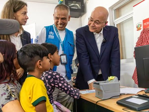 El Alto Comisionado de la ONU para los Refugiados, Barham Salih, y funcionarios de ACNUR hablan con una familia de Venezuela en un centro de protección de Lima, Perú.