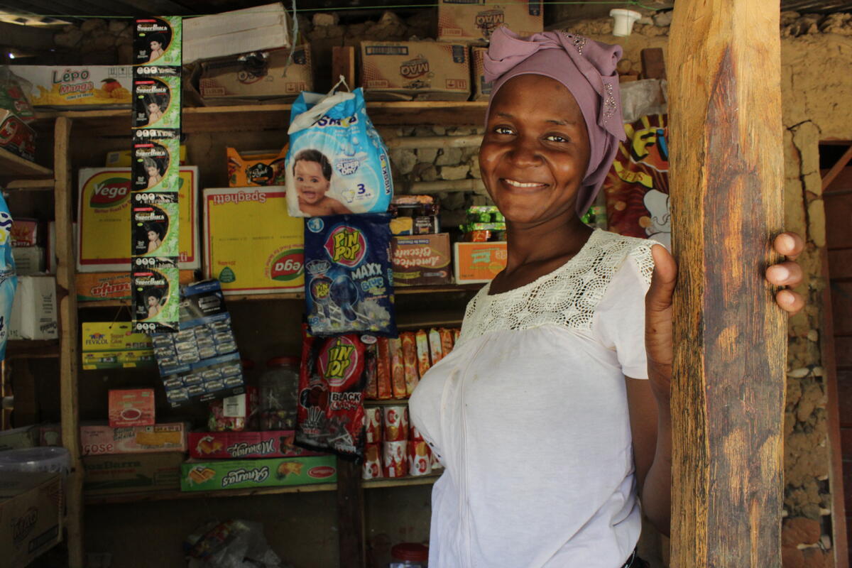 Una joven sonríe desde la puerta de una pequeña tienda
