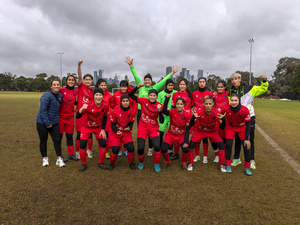 Un equipo de fútbol femenil posa para una fotografía en una cancha.