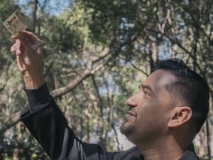 Un hombre joven observa emocionado la identificación que sostiene en la mano