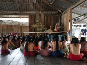 Mujeres Wounaan de espaldas frente a imágenes religiosas