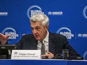 Un hombre cano que lleva puesto un saco habla frente a un micrófo. Frente a él hay una placa que dice "Filippo Grandi, Alto Comisionado de la ONU para los Refugiados" y detrás suyo hay una pared con logotipos del Foro Mundial sobre los Refugiados