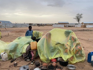 Personas refugiadas recién llegadas de Sudán usan lonas de plástico para protegerse de la lluvia en un asentamiento informal Adre, en el este de Chad.