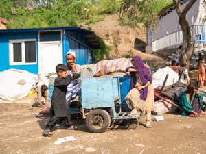 Después de regresar desde Pakistán, una familia afgana exhausta descansa junto a sus pertenencias en el cruce fronterizo de Torkham.