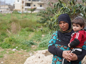 Khadra, refugiada siria, sostiene en brazos a su sobrino en el asentamiento informal de tiendas de campaña del norte del Líbano donde vive con su familia.