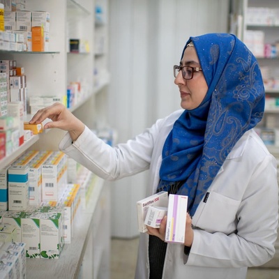 Una mujer repone medicamentos en una farmacia