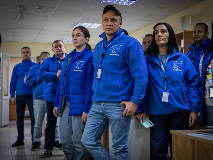 Un grupo de personas de chaqueta azul posa para la cámara.
