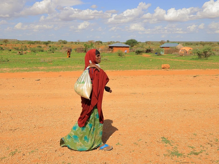 Etiopía. Ilama Ahmed, de 31 años, desplazada interna, camina hacia su casa con los alimentos que compró al propietario de una tienda, Ahmed Salah Ahmed, en el campamento de desplazados internos de Darso.