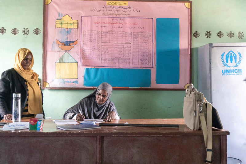 Susan Zein Faisal Allah Al-Kamali (al centro), Directora de la Escuela Secundaria para niñas Al Jabalain, revisa documentos en un aula.