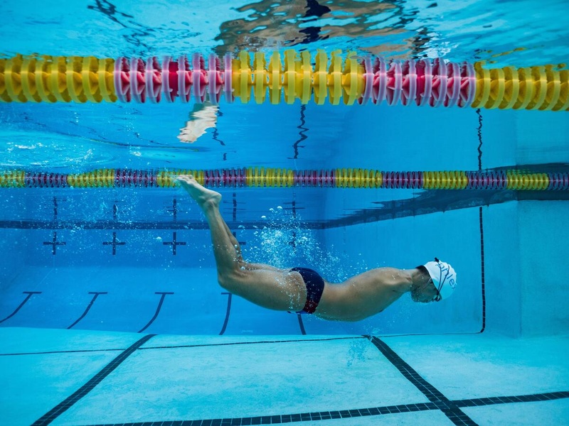 Un hombre con discapacidad nada en una piscina