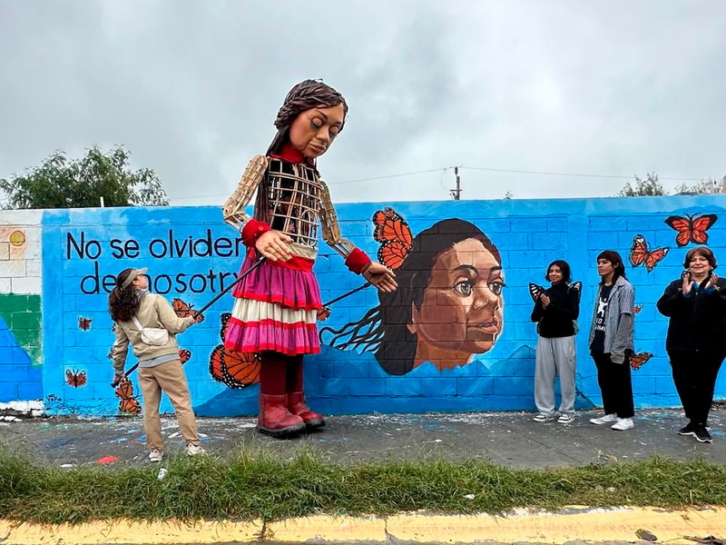 La pequeña Amal frente al mural realizado en su honor, que la retrata rodeada de mariposas..