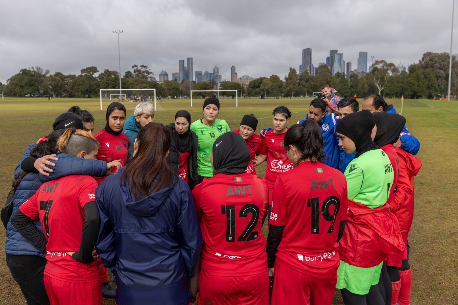 Un equipo de fútbol femenil se abraza en una cancha