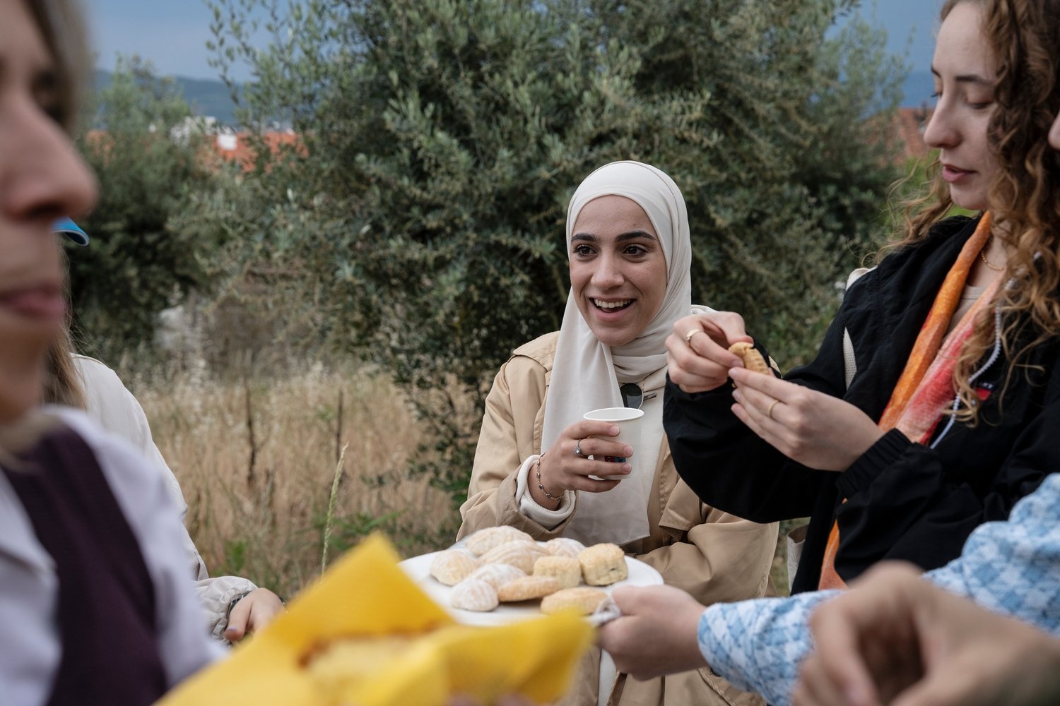 Una joven ríe mientras reparten comida en un picnic.