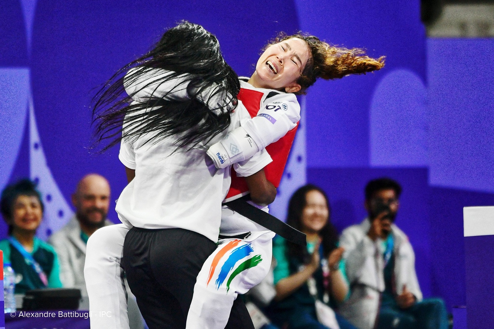 Una emocionada atleta salta a los brazos de su entrenadora.
