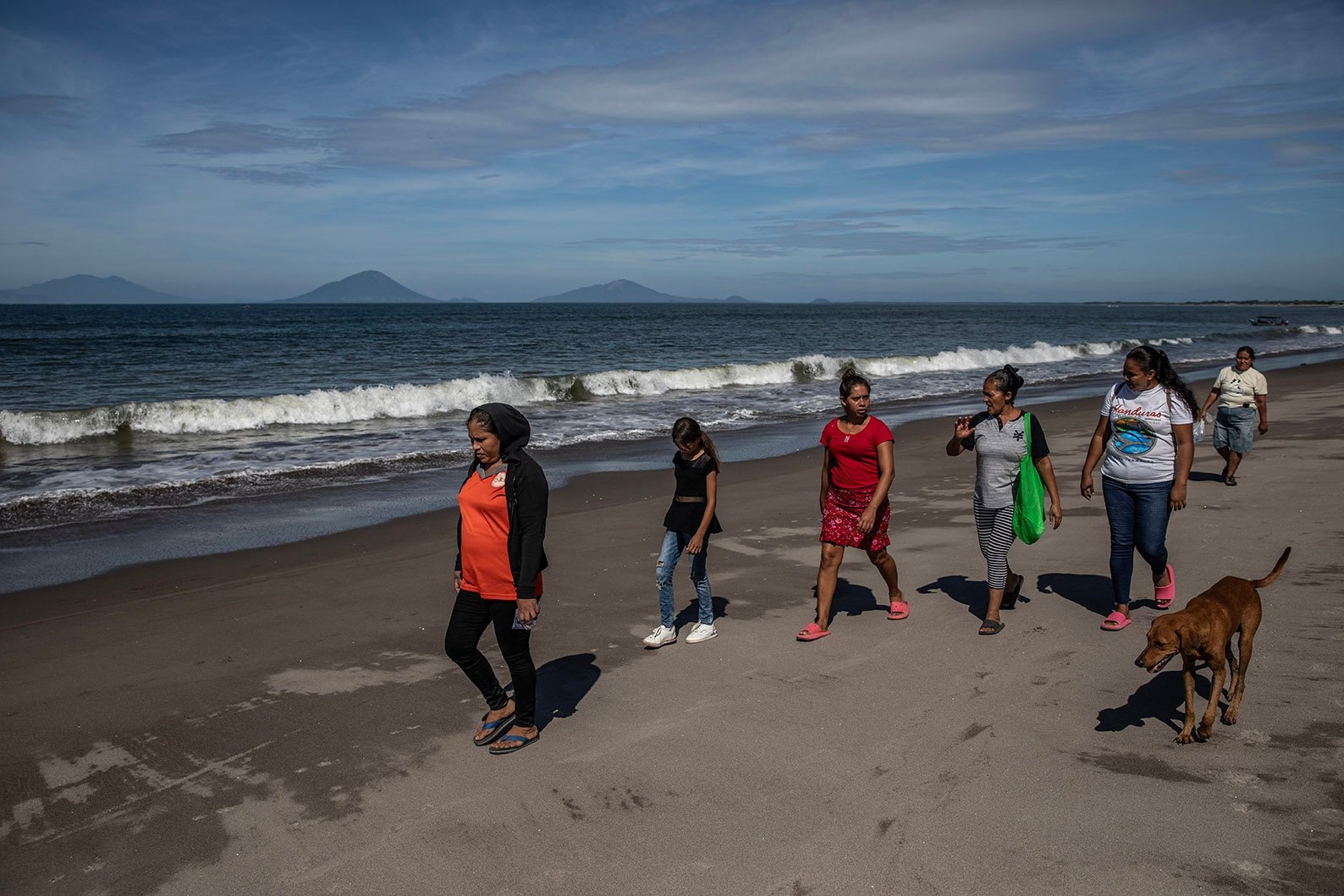 Un grupo de mujeres caminando en una playa.