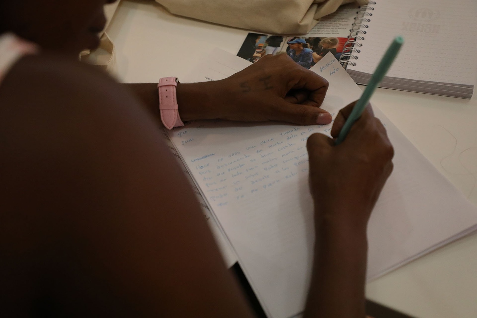 Primera plana de unas manos escribiendo una carta.