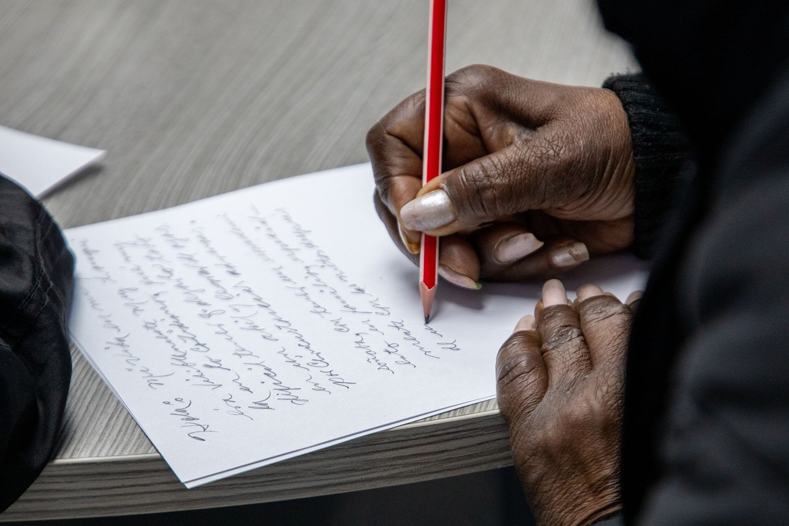 Primera plana de unas manos escribiendo una carta.