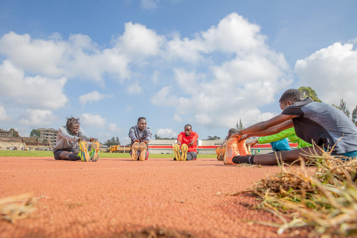 Un grupo de personas estira en una pista de atletismo