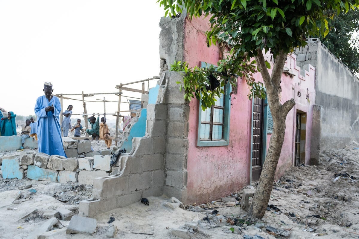 Un hombre en las ruinas de una casa de la que solo queda en pie la fachada