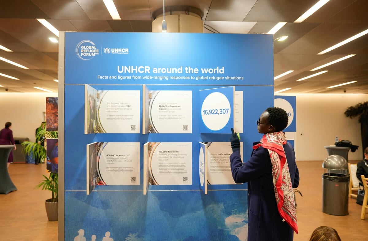 Una mujer interactúa con una pieza de la exposición “ACNUR alrededor del mundo”.