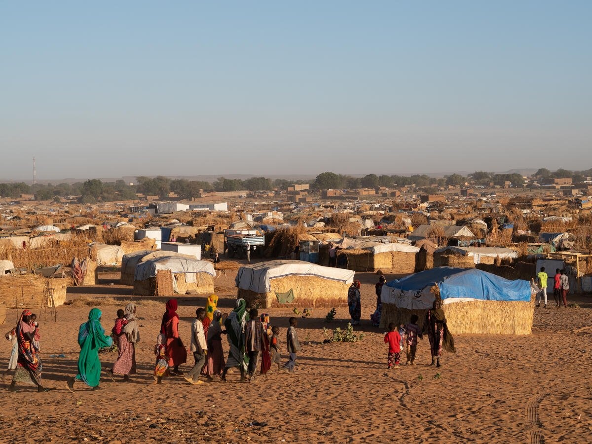Decenas de personas caminan en un campamento de refugiados