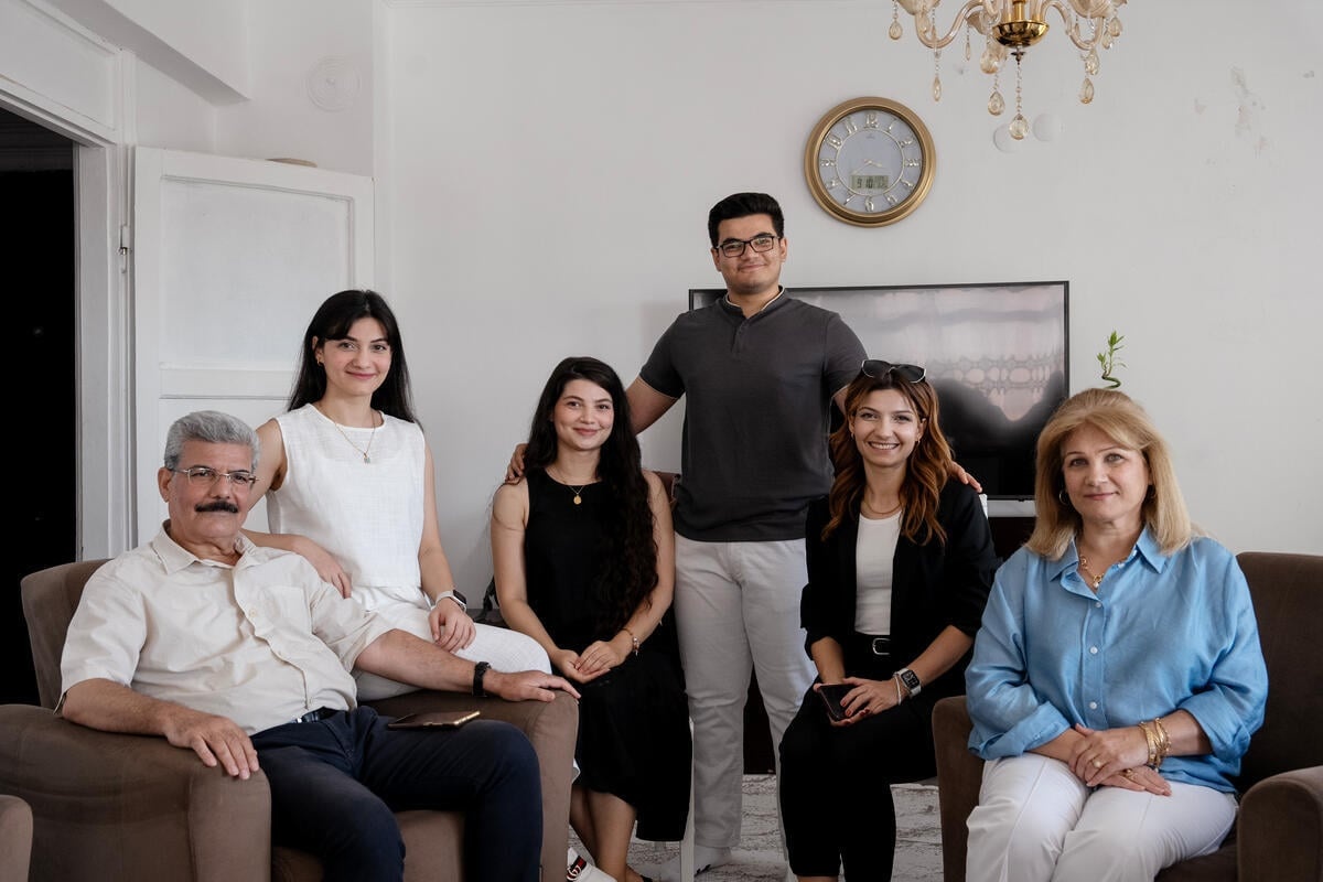 Una familia de seis miembros posa en una sala