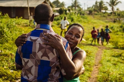 Un refugiado de Côte d'Ivoire recibe un abrazo de su tía al volver a casa