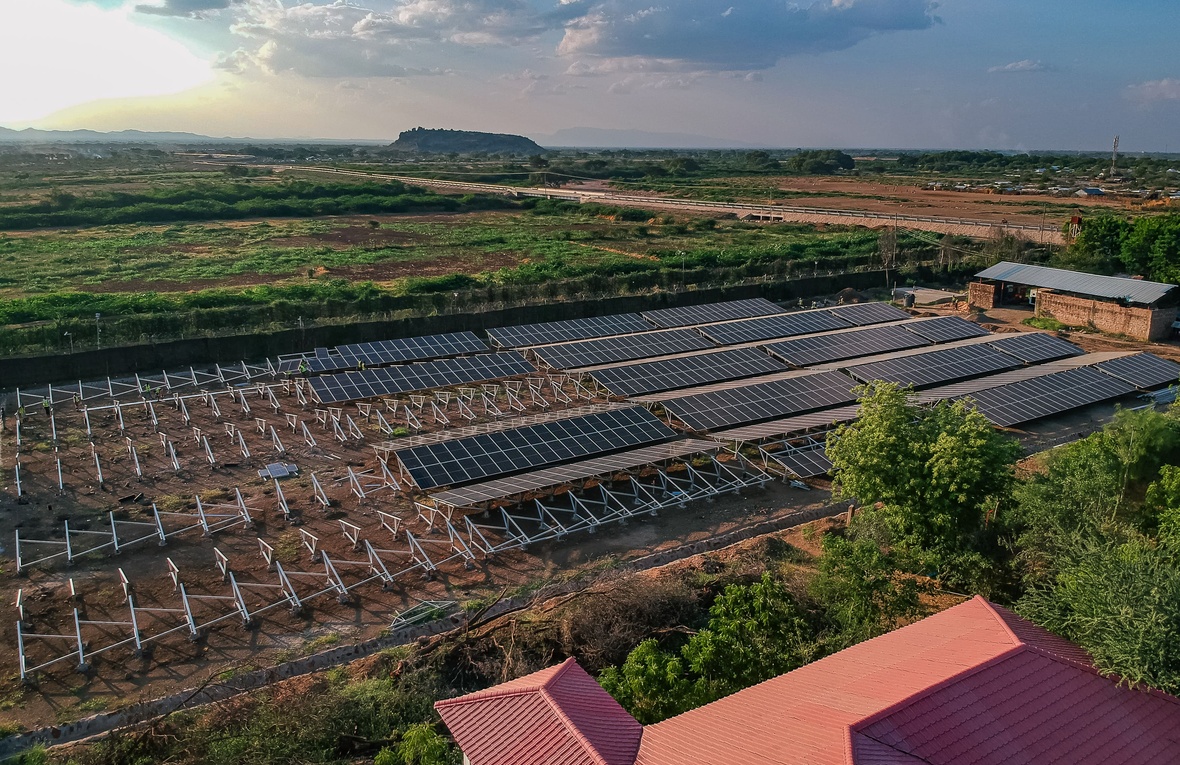 Toma aérea de la minirred solar en un entorno árido con otros edificios alrededor
