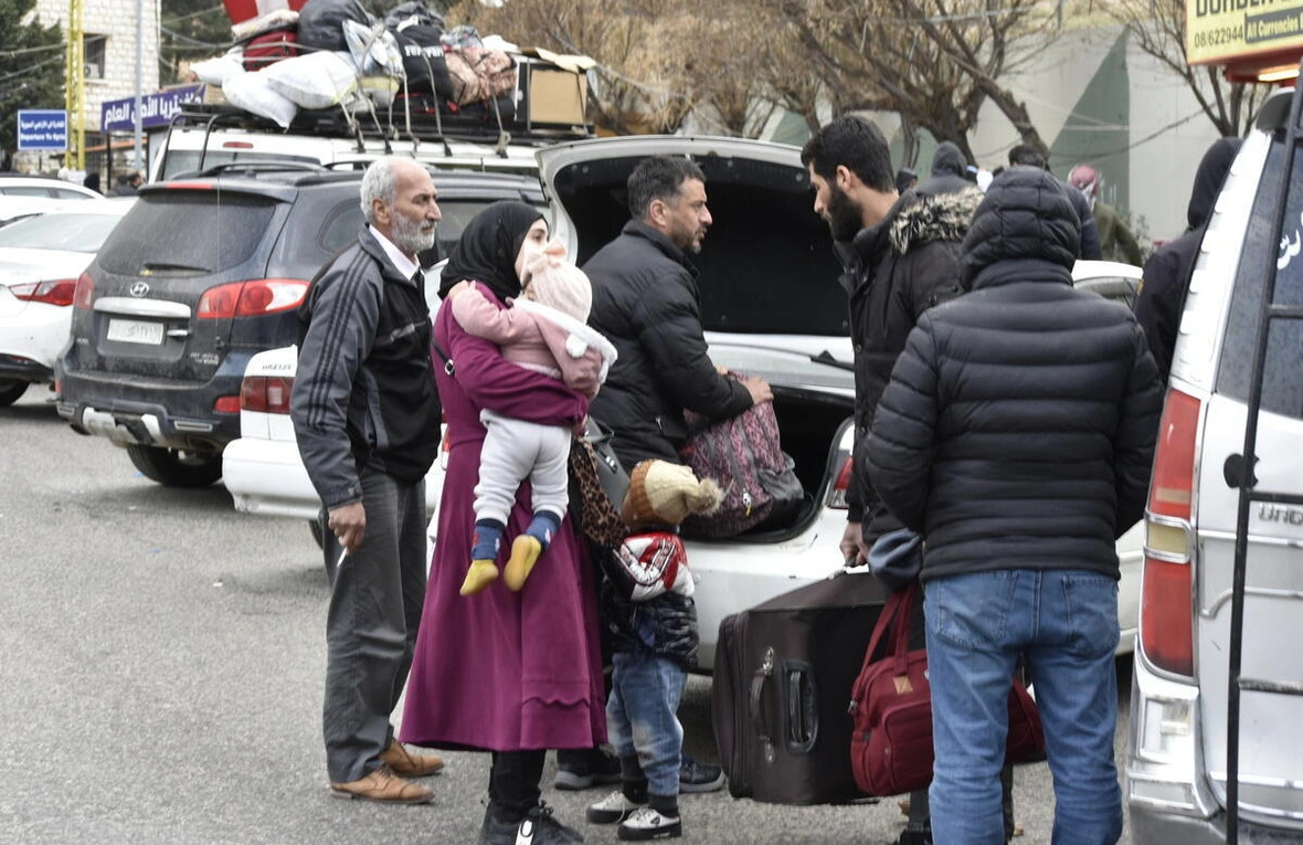 Una familia llega al paso fronterizo de Masnaa, en el Líbano, para cruzar hacia Siria y ponerse a salvo de los bombardeos israelíes y las órdenes de evacuación.
