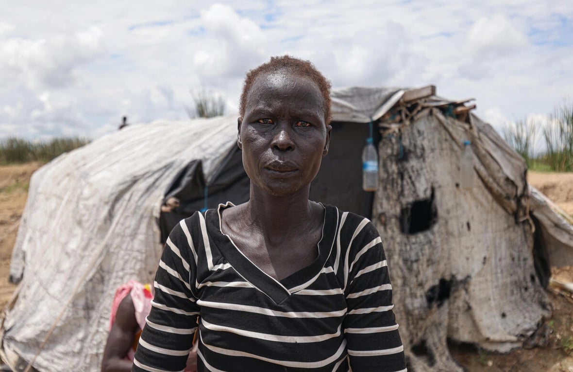 Aduot Wuoi Monjuon, desplazada interna, posa junto a su refugio en Bor, Sudán del Sur, donde se ha desplazado después de que las inundaciones la obligaran a huir de su aldea en el Estado de Jonglei, junto a su familia.