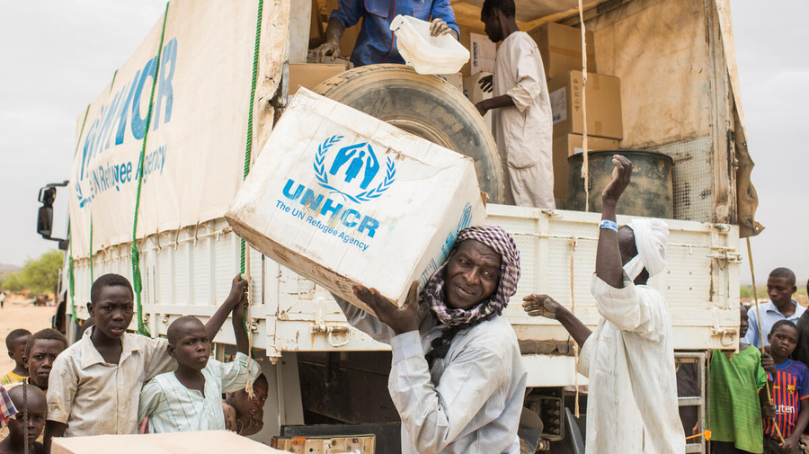 Un grupo de hombres descarga suministros de ACNUR de un camión en Chad