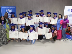 Un grupo de estudiantes recién graduados posa mostrando sus diplomas.