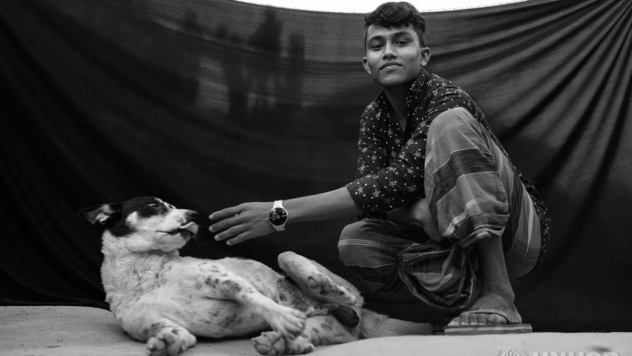 Refugiado rohingya Jamir,15 anos, senta com seu cão Shikari. © ACNUR / Brian Sokol