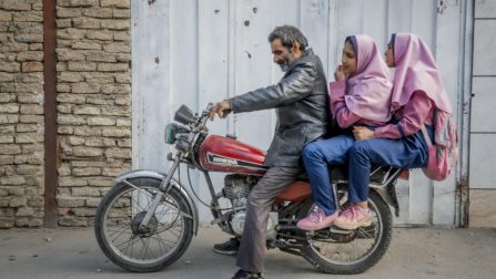 O refugiado afegão Besmellah leva suas filhas Parisa e Parimahpara a escola, que fica a 10 quilômetros da casa onde moram em Esfahan, no Irã
