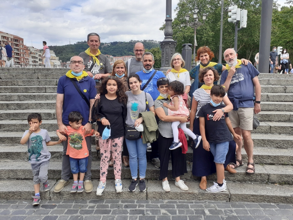 Majed (ao centro de camiseta azul) e sua família com voluntários da Caritas Bilbao, incluindo Vicente Villate (atrás, à esquerda, de camisa cinza e lenço amarelo) 