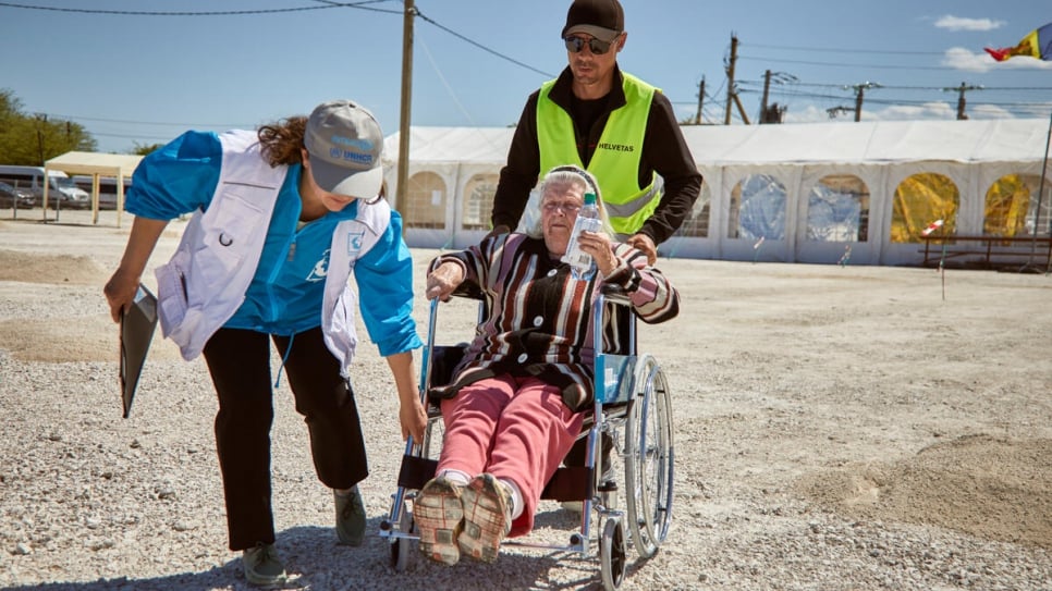Funcionários do ACNUR ajudam Svetlana de 83 anos depois de chegar à fronteira de Palanca, na Moldávia, vinda da Ucrânia. ACNURAndrew McConnell