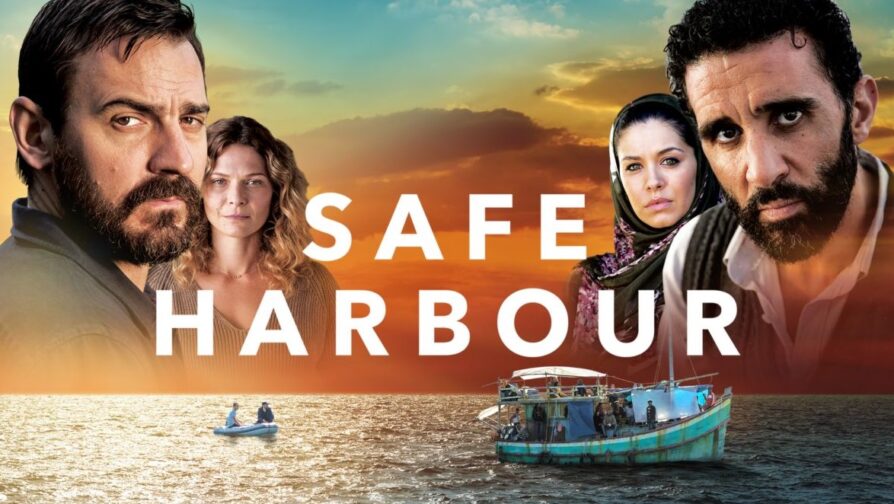 A foto é a capa do filme Safe Harbour, mostrando um oceano com um barco em sua parte inferior, enquanto no enquadramento superior há duas mulheres e dois homens, os quais fazem parte do elenco do filme.