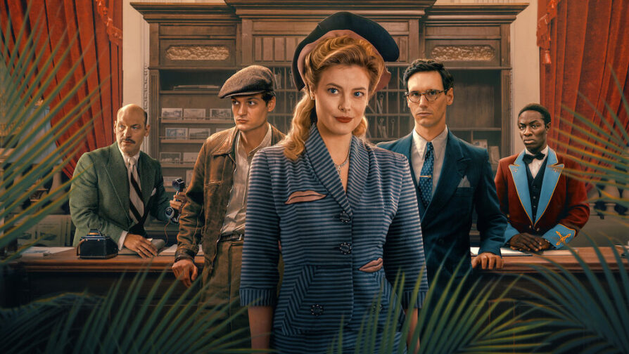 A imagem é formada por uma mulher ao centro e 4 homens atrás, os quais usam roupas formais e estão localizados em uma recepção. A cena é parte do filme Transatlântico.
