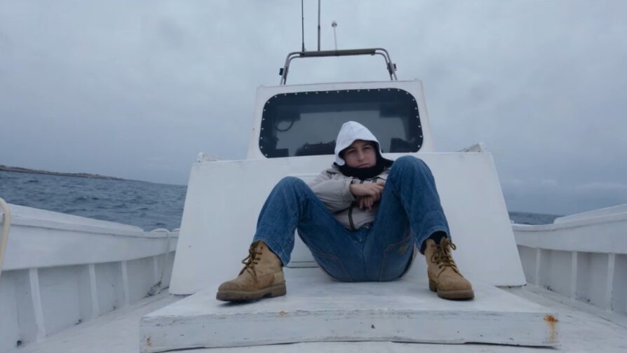 Imagem do documentário Fogo no Mar (2016), de Gianfranco Rosi. A foto mostra Samuele, garoto de 12 anos sentado em um barco no Mar Mediterrâneo.