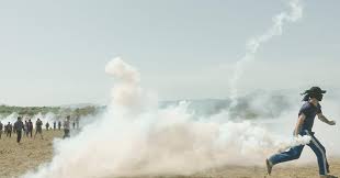 Imagem do documentário The Rest (2019), de Ai Weiwei. A foto mostra um homem correndo enquanto solta fumaça, com o rosto coberto.