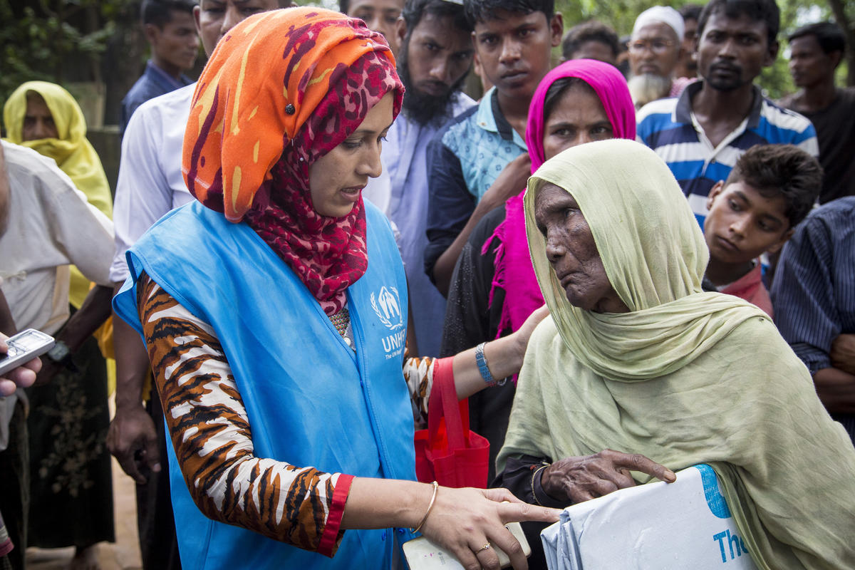 Una mujer mayor recibe una lona de plástico de una trabajadora de ACNUR en el campamento de refugiados de Kutupalong, en Bangladesh.