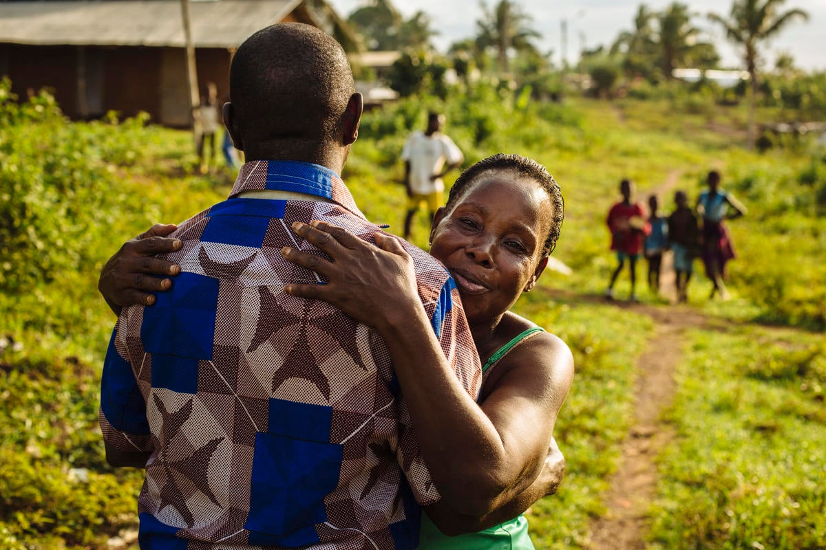 Un refugiado de Côte d'Ivoire recibe un abrazo de su tía al volver a casa