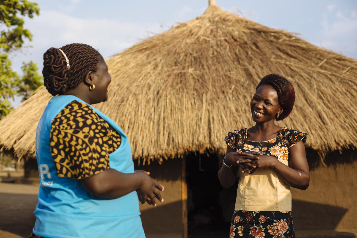 Dos mujeres africanas conversan; una de ellas (la que está a la izquierda) trabaja en ACNUR.