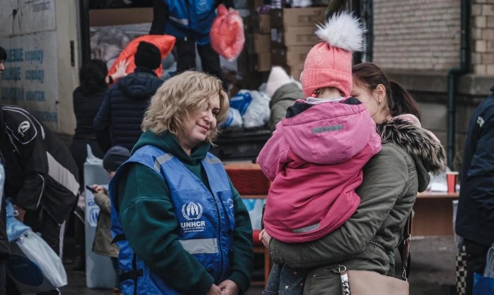 Anzhela, 24 años, carga a sobrina Liliya, de 4 años, mientras están en fila para recibir ropa de abrigo y mantas.