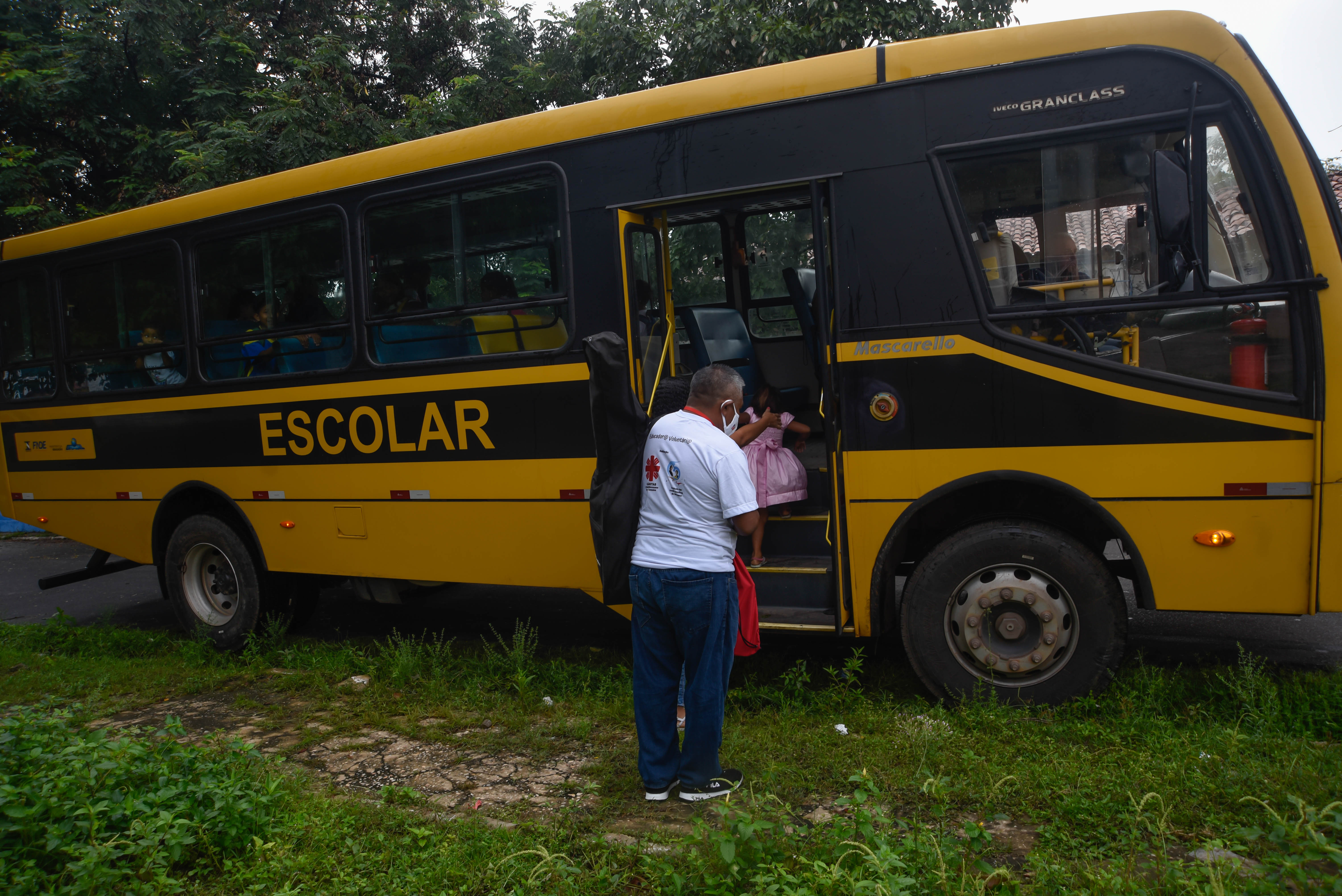 Plácido sube al autobús escolar con los niños y adolescentes.