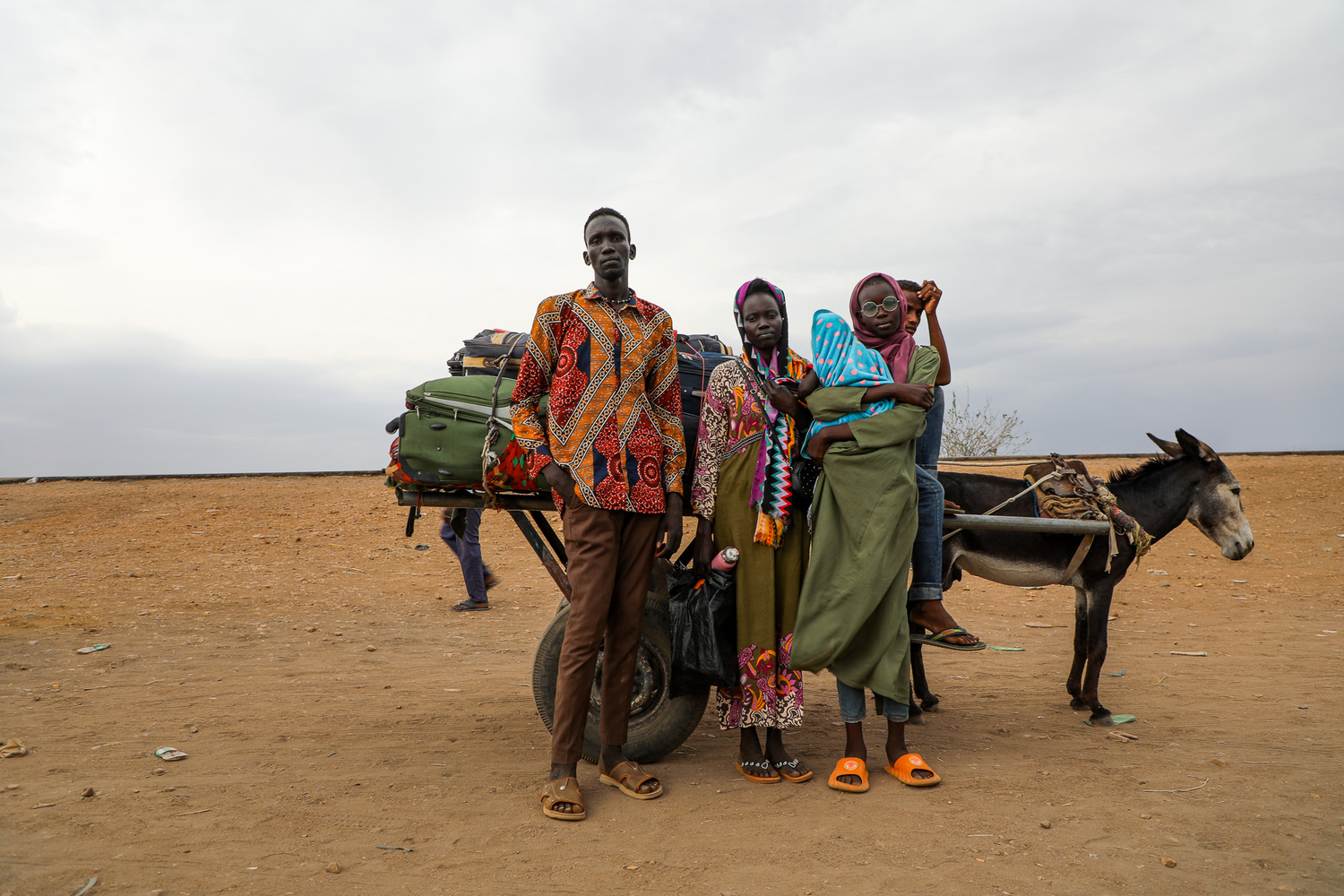 Una familia sudsudanesa retornada junto a un carro tirado por burros en el que llevan sus pertenencias