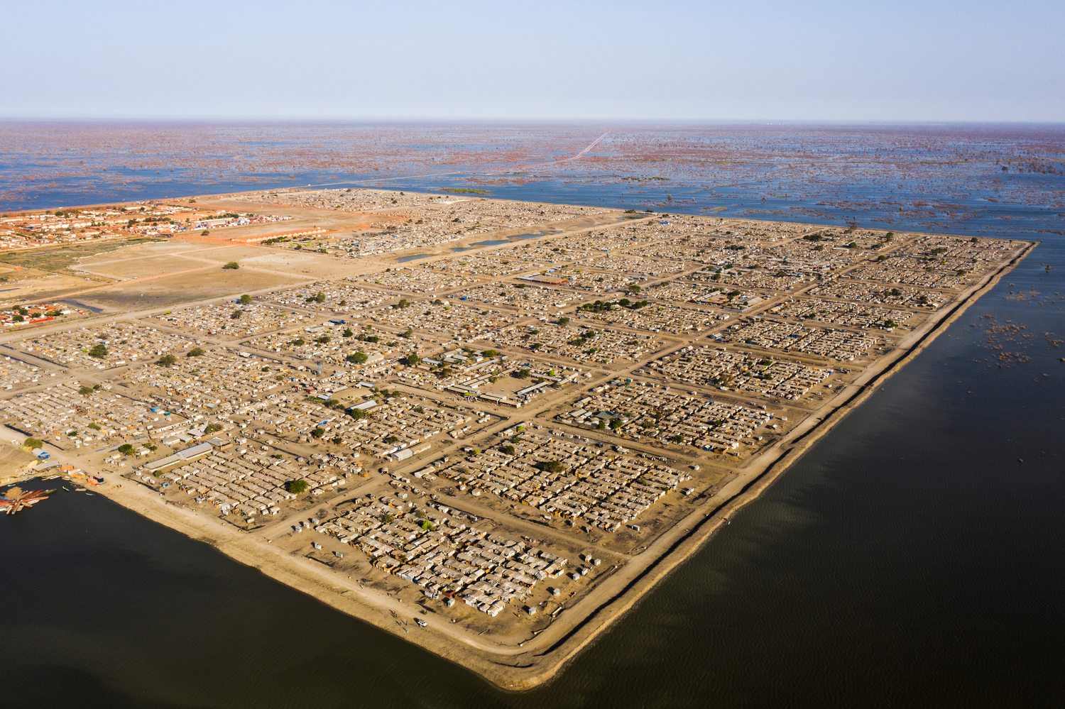 A settlement surrounded by flood waters so it resembles an island. Un asentamiento rodeado por el agua de las inundaciones, por lo que se asemeja a una isla.