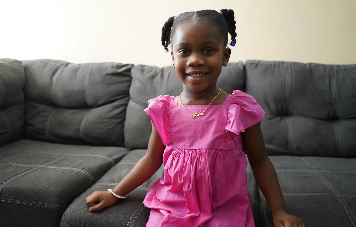 Una niña afrodescendiente refugiada en un sillón